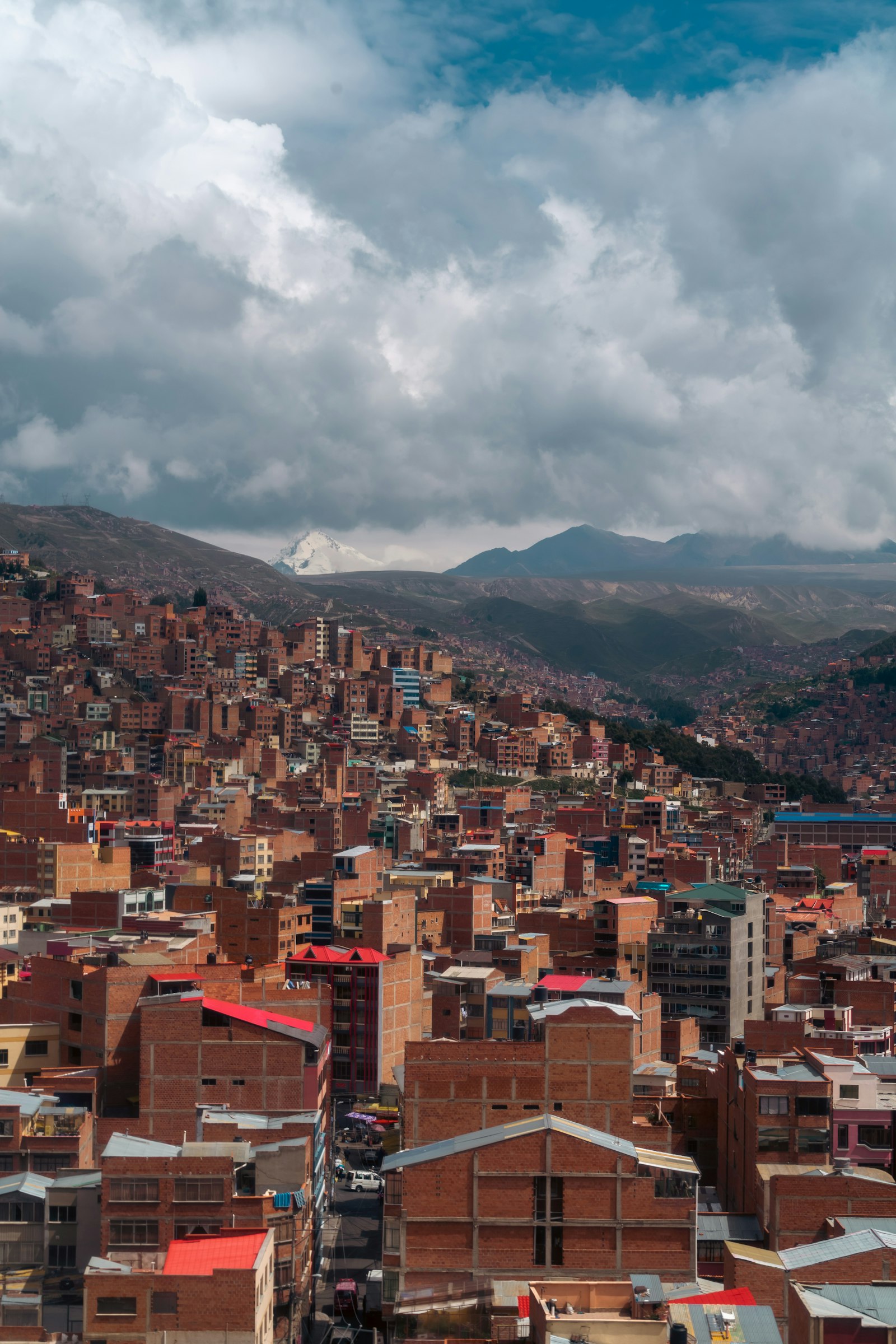 Aerial view of the La Paz skyline with high-rise buildings and snow-covered mountains in the background
